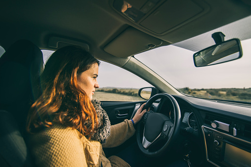 A young girl driving a car